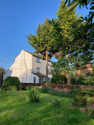 Older house in Little Bowden with mature trees in garden